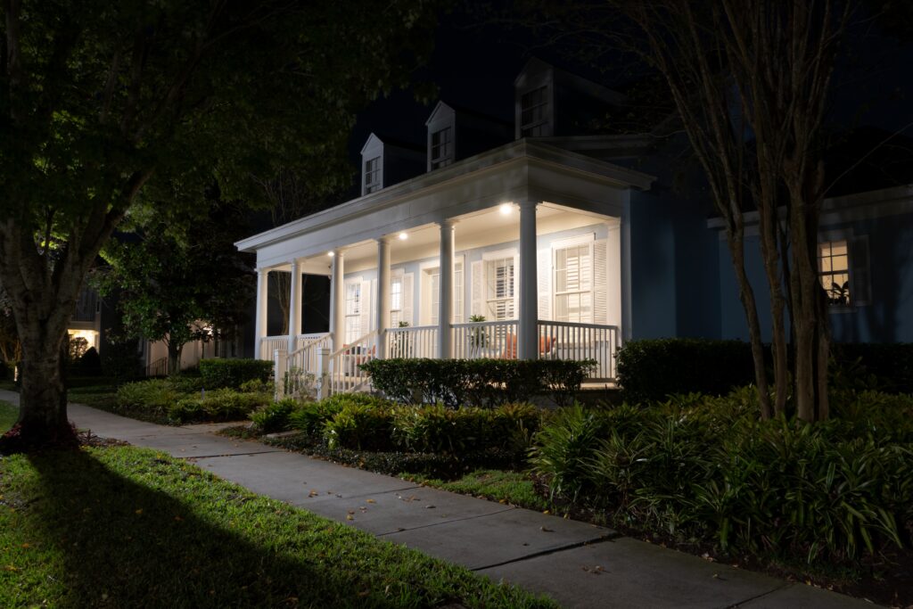 house in HOA community at night with front porch lights on