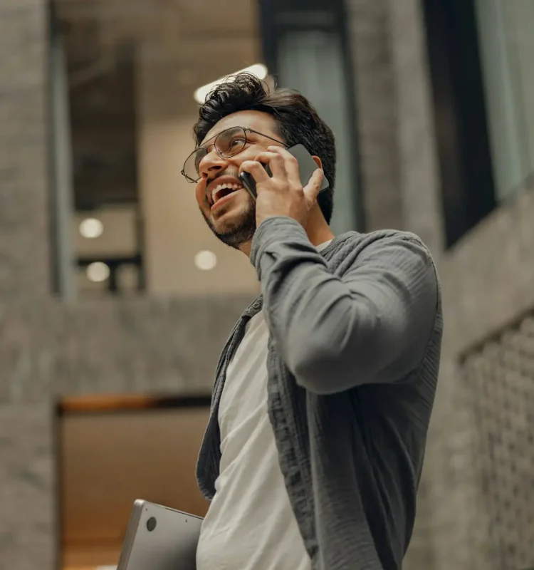 stylish-businessman-in-eyeglasses-is-talking-phone-standing-in-modern-coworking-space.jpg